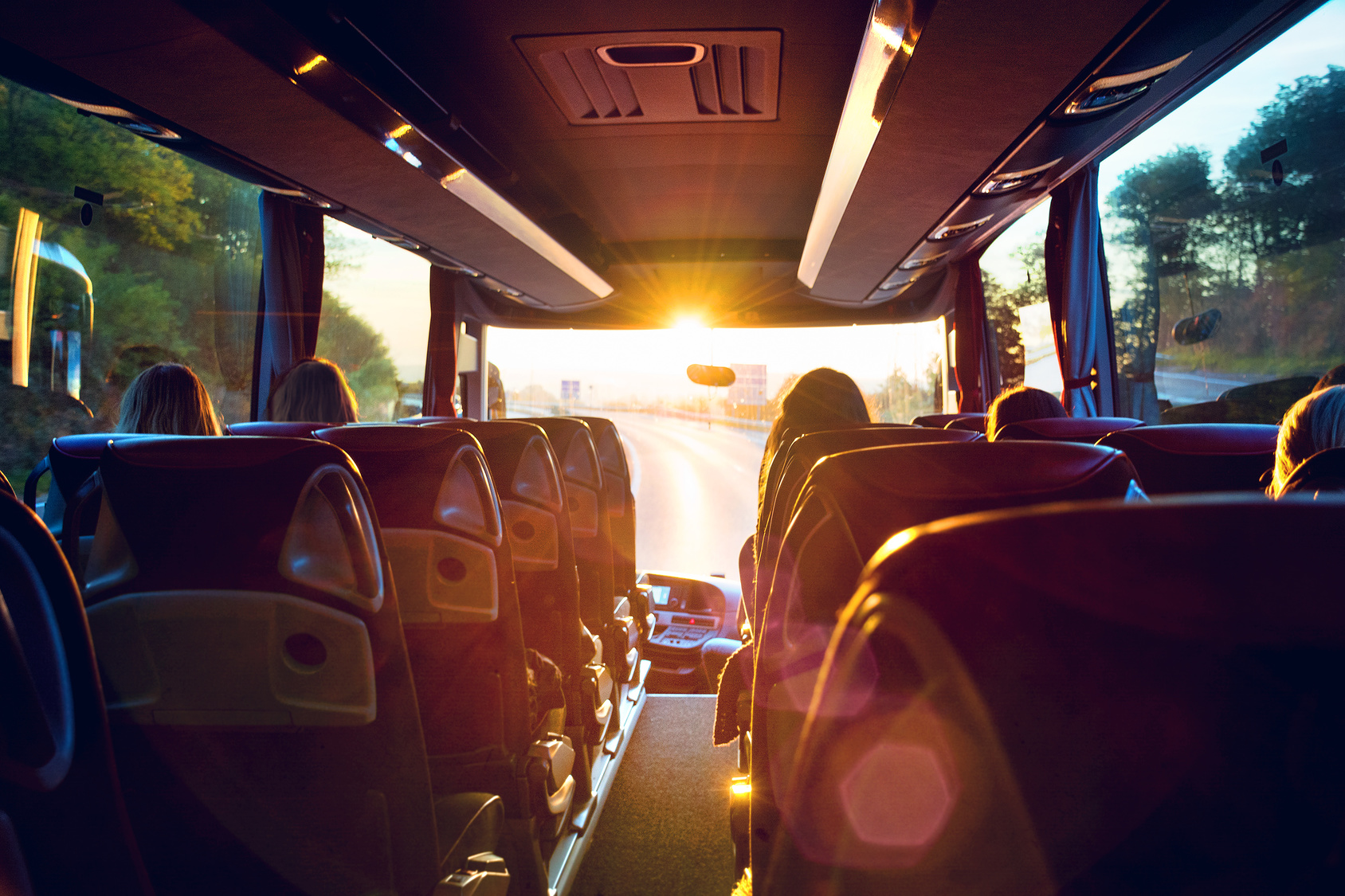 Reisende im Bus bei sonniger Fahrt